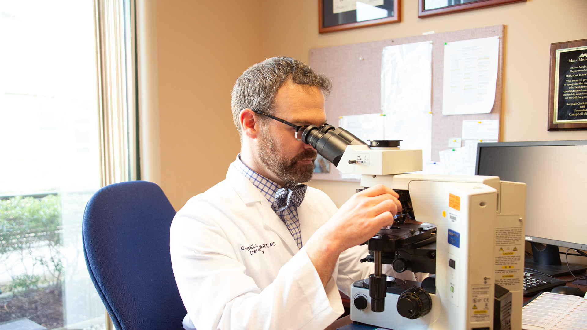 Dr. Campbell Stewart studies a sample through a microscope